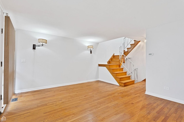 1652 W Jarvis Ave, Chicago, IL 60626 - unfurnished living room featuring light wood-style floors, baseboards, and stairs