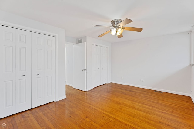 1652 W Jarvis Ave, Chicago, IL 60626 - unfurnished bedroom featuring two closets, ceiling fan, light wood-type flooring, visible vents, and baseboards