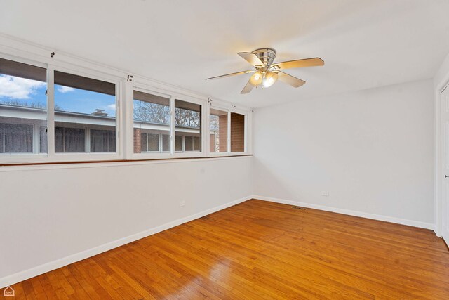 1652 W Jarvis Ave, Chicago, IL 60626 - spare room with visible vents, baseboards, a ceiling fan, and wood finished floors