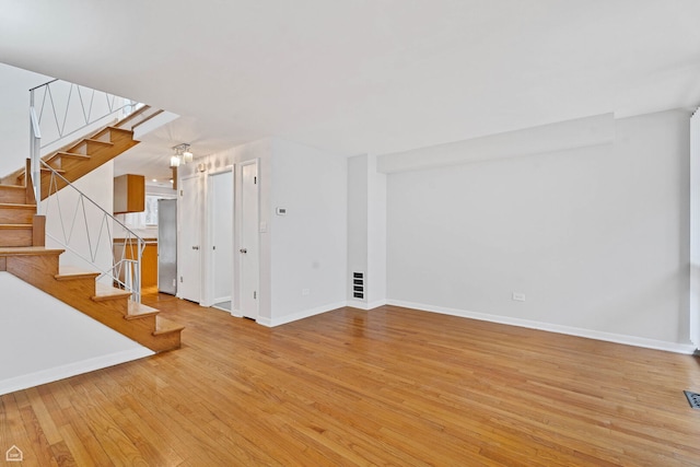 1652 W Jarvis Ave, Chicago, IL 60626 - unfurnished living room featuring visible vents, baseboards, wood finished floors, and stairs