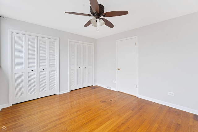 1652 W Jarvis Ave, Chicago, IL 60626 - unfurnished bedroom with light wood finished floors, baseboards, and multiple closets