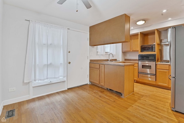 1652 W Jarvis Ave, Chicago, IL 60626 - kitchen featuring a peninsula, light wood-type flooring, a warming drawer, stainless steel appliances, and baseboards