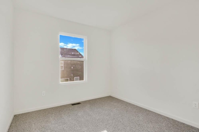 carpeted empty room featuring visible vents and baseboards