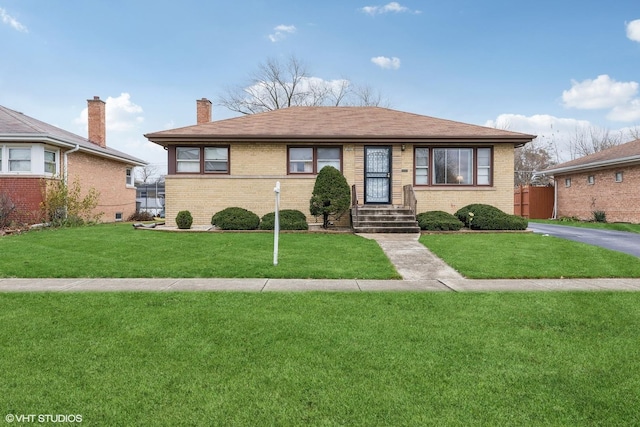 view of front of property with brick siding, a chimney, and a front lawn