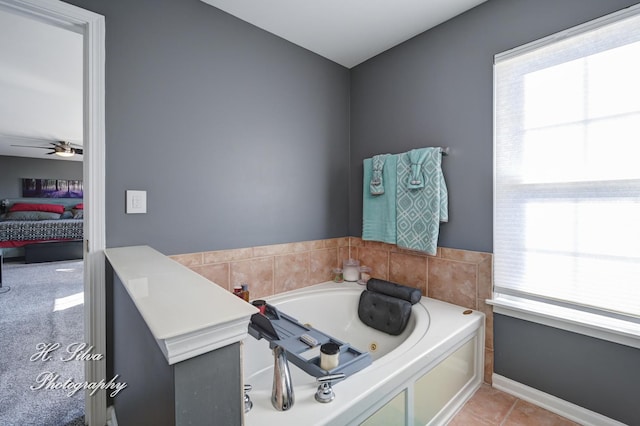 ensuite bathroom with plenty of natural light, a jetted tub, ensuite bath, and a ceiling fan