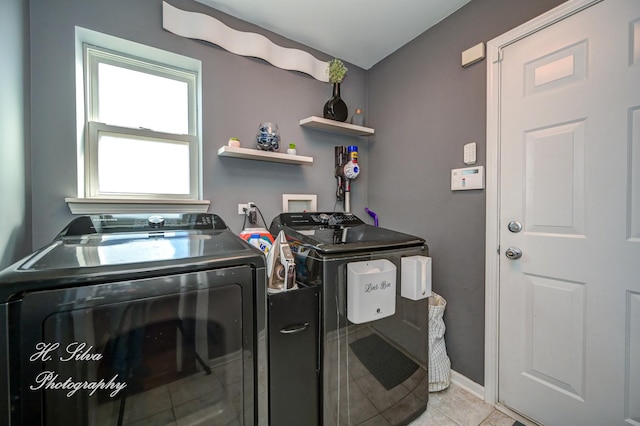 washroom with independent washer and dryer, light tile patterned flooring, and laundry area