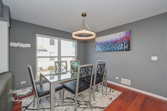 dining room featuring visible vents, baseboards, and wood finished floors