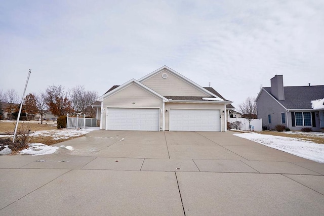 view of front of property with concrete driveway and fence