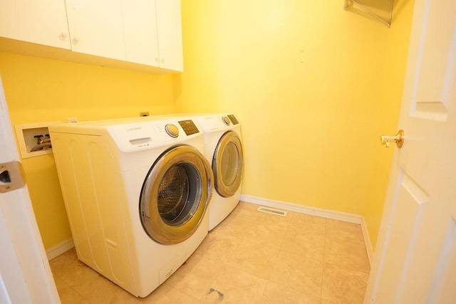 clothes washing area with cabinet space, independent washer and dryer, visible vents, and baseboards