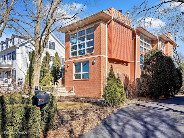 view of side of property with brick siding and a chimney