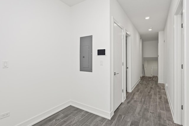 hall with wood tiled floor, electric panel, and baseboards