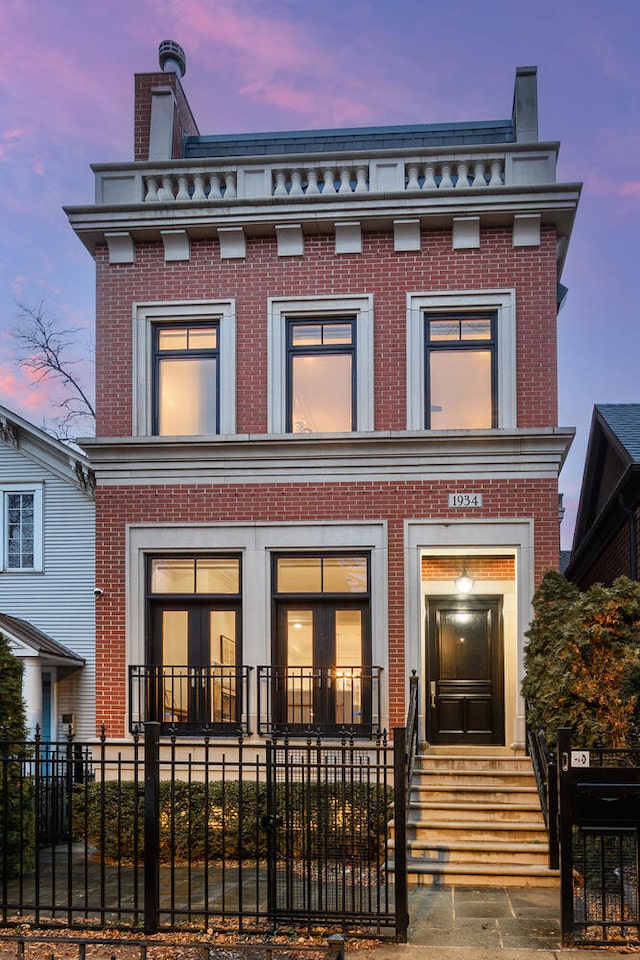 view of front facade with a fenced front yard and brick siding