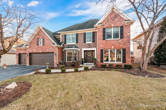 view of front facade with aphalt driveway, brick siding, an attached garage, and a front lawn