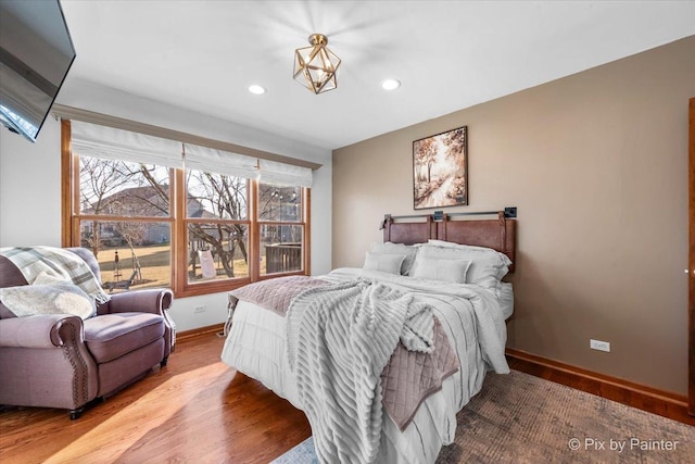 bedroom with baseboards, wood finished floors, and recessed lighting