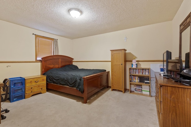 bedroom with light carpet and a textured ceiling