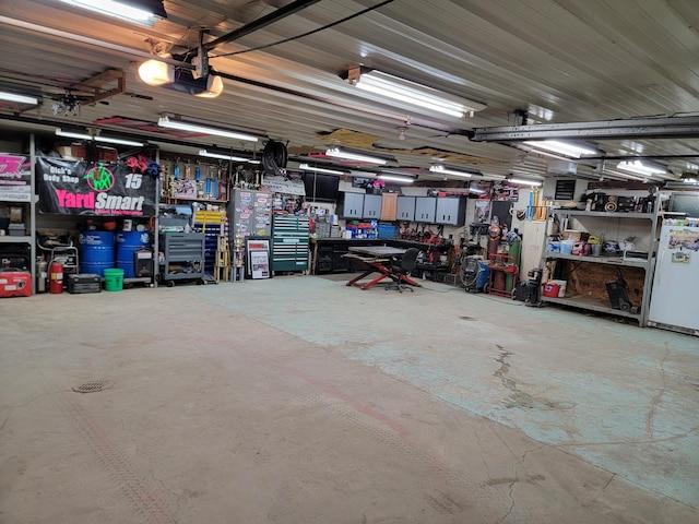 garage featuring a garage door opener, fridge, and a workshop area