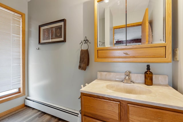 bathroom with a baseboard heating unit, vanity, and wood finished floors