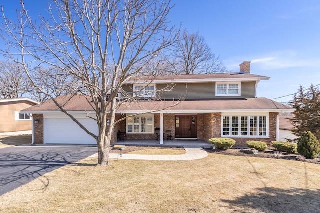 traditional-style home featuring driveway, covered porch, a chimney, a garage, and brick siding