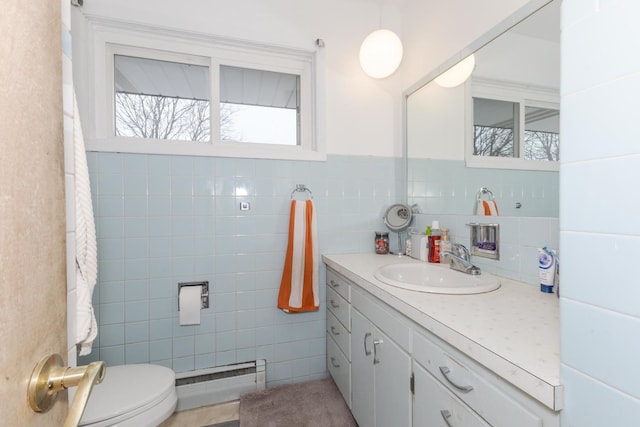 bathroom featuring tile walls, toilet, a baseboard heating unit, wainscoting, and vanity