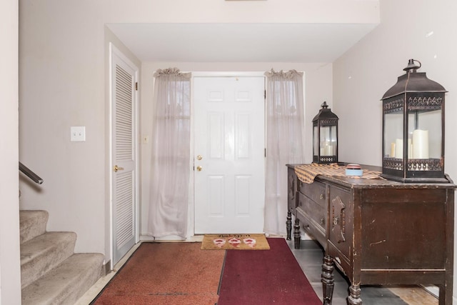 foyer featuring carpet floors and stairway