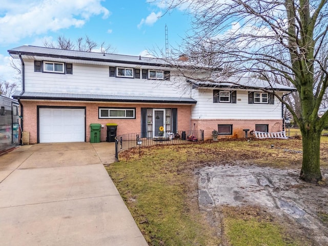 split level home with concrete driveway, brick siding, and an attached garage