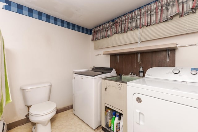 clothes washing area with a baseboard heating unit, laundry area, washer and clothes dryer, and baseboards