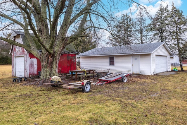 view of yard featuring a garage and an outbuilding