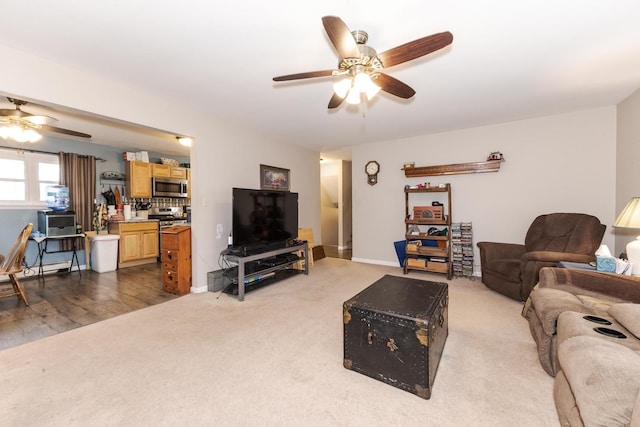 living area with ceiling fan, carpet flooring, and baseboards