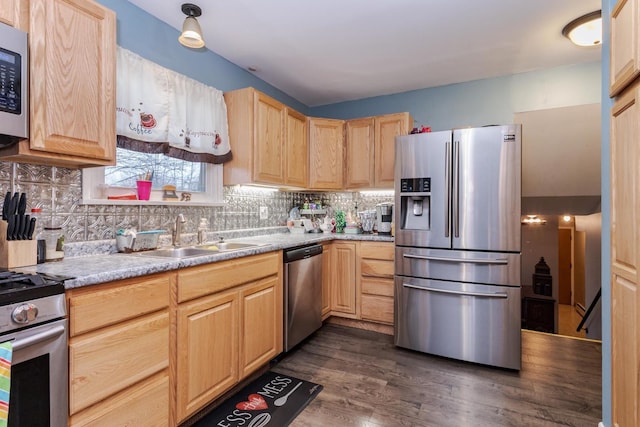 kitchen featuring tasteful backsplash, appliances with stainless steel finishes, a sink, and light brown cabinetry