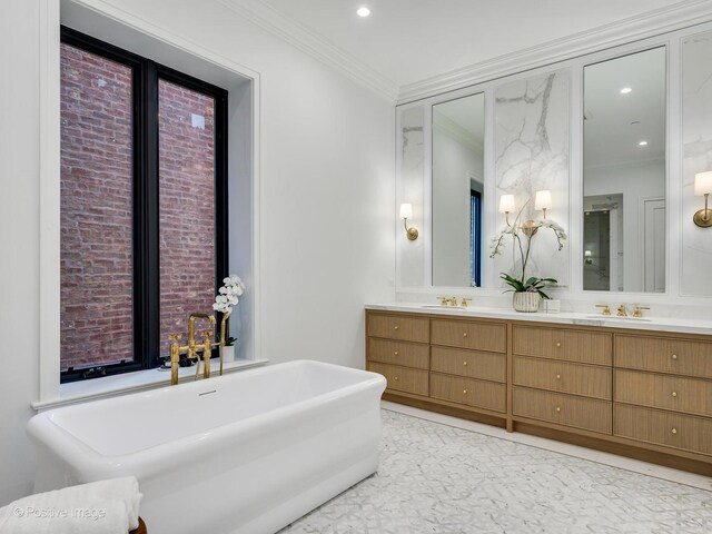 bathroom featuring double vanity, recessed lighting, ornamental molding, a sink, and a freestanding tub