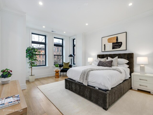 bedroom with light wood finished floors, visible vents, baseboards, crown molding, and recessed lighting