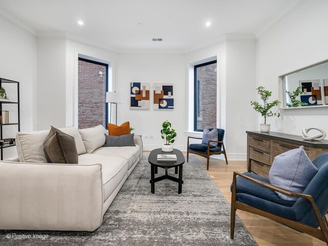 living room with crown molding, baseboards, and wood finished floors