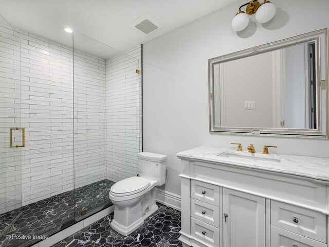 full bathroom featuring visible vents, toilet, vanity, a shower stall, and baseboards