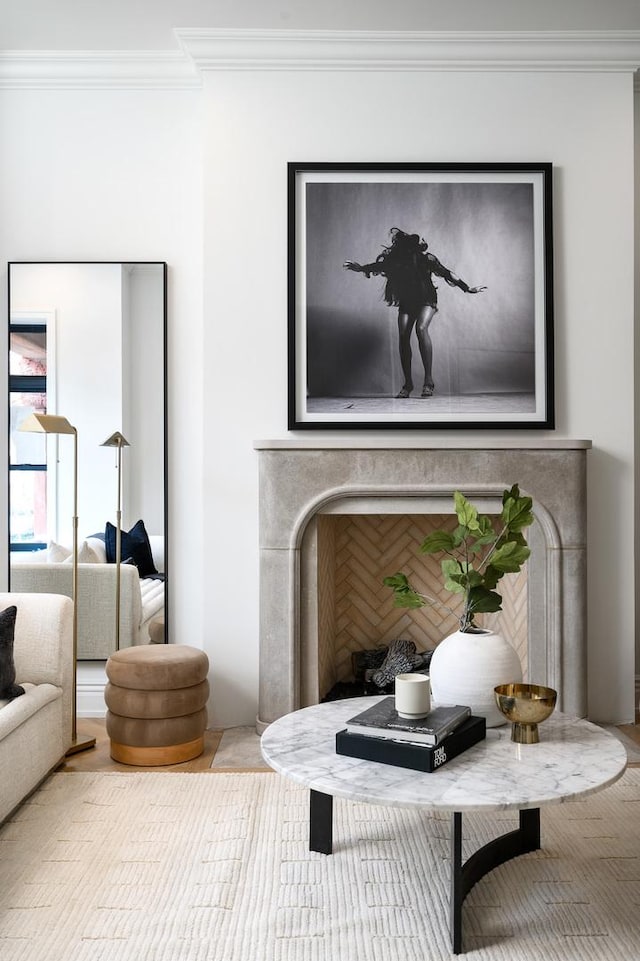 living area featuring a fireplace and crown molding