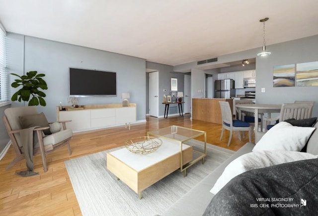 living room with light wood-type flooring and visible vents