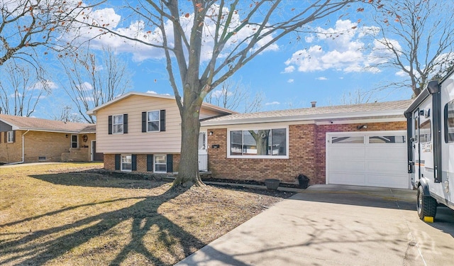 tri-level home with a front lawn, concrete driveway, brick siding, and an attached garage