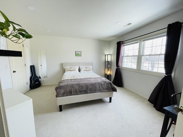 bedroom featuring baseboards, visible vents, and light colored carpet