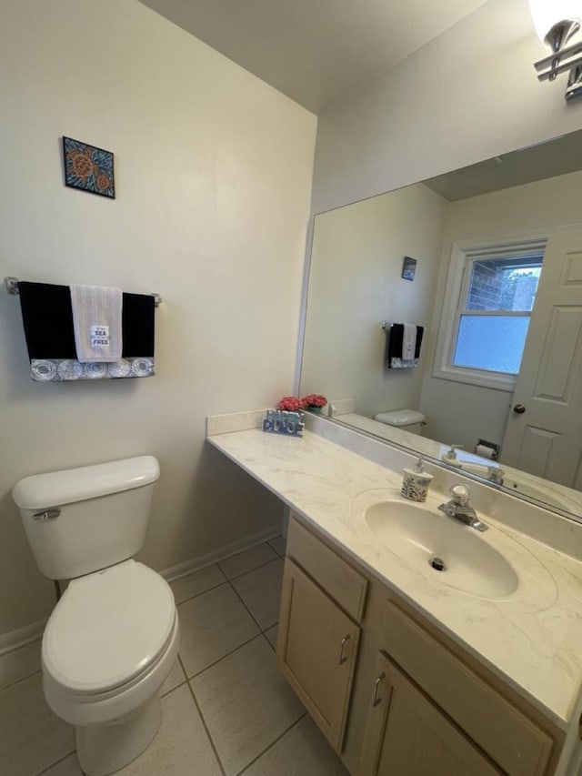 half bathroom with baseboards, toilet, vanity, and tile patterned floors