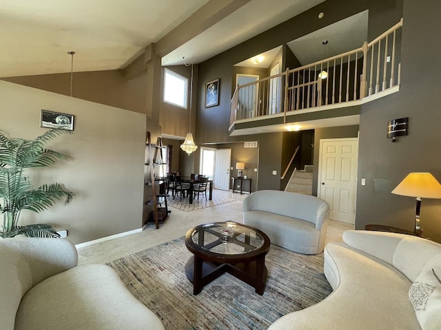 carpeted living area featuring stairs, high vaulted ceiling, and baseboards