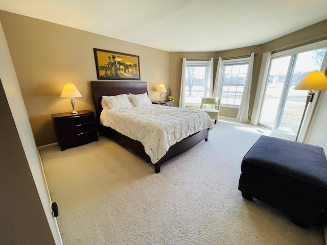 bedroom with carpet floors, access to outside, and baseboards