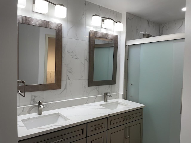 full bath featuring double vanity, decorative backsplash, and a sink