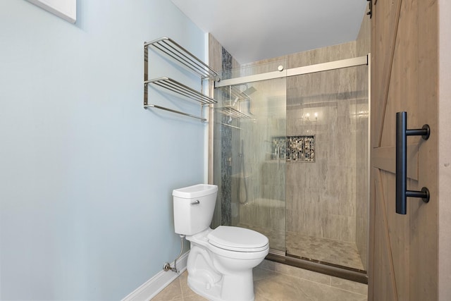 full bathroom featuring a stall shower, baseboards, toilet, and tile patterned floors