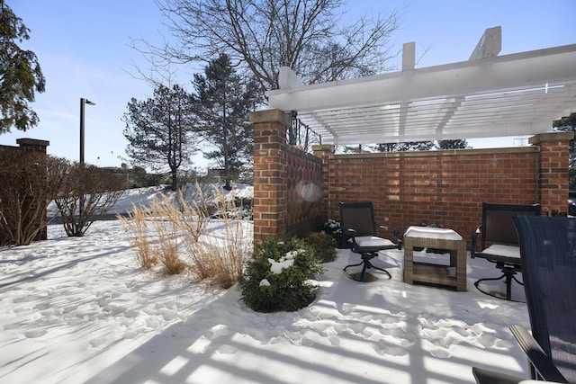 snow covered patio featuring a pergola