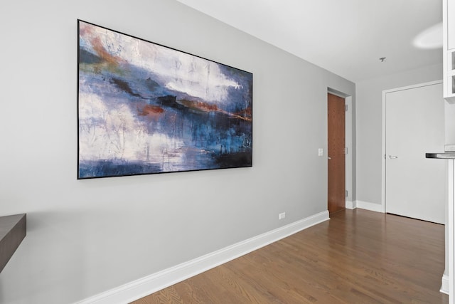 empty room featuring baseboards and wood finished floors