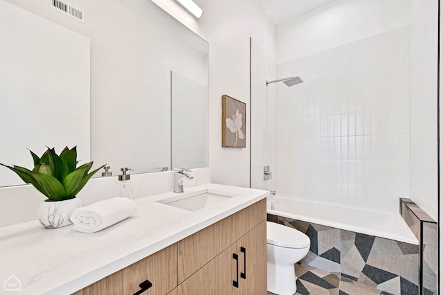 bathroom with visible vents, tiled shower / bath, toilet, and vanity