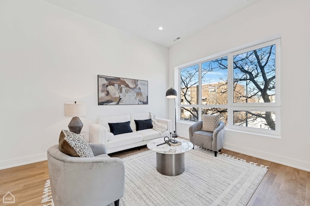 living area featuring recessed lighting, wood finished floors, visible vents, and baseboards