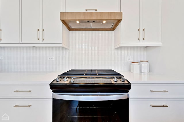 kitchen featuring light countertops, stainless steel gas range, custom exhaust hood, and white cabinetry