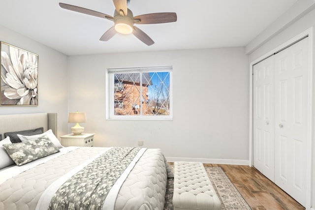 bedroom with a ceiling fan, a closet, baseboards, and wood finished floors