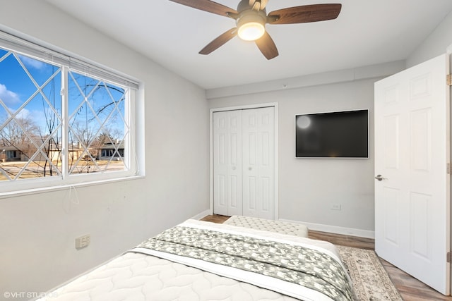 bedroom with ceiling fan, a closet, baseboards, and wood finished floors