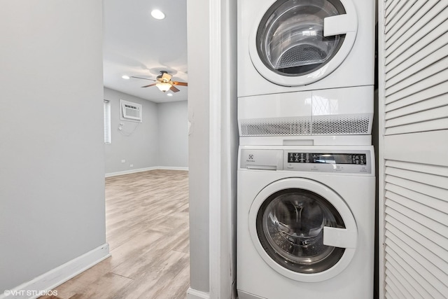 laundry area featuring ceiling fan, laundry area, baseboards, stacked washer / drying machine, and light wood finished floors